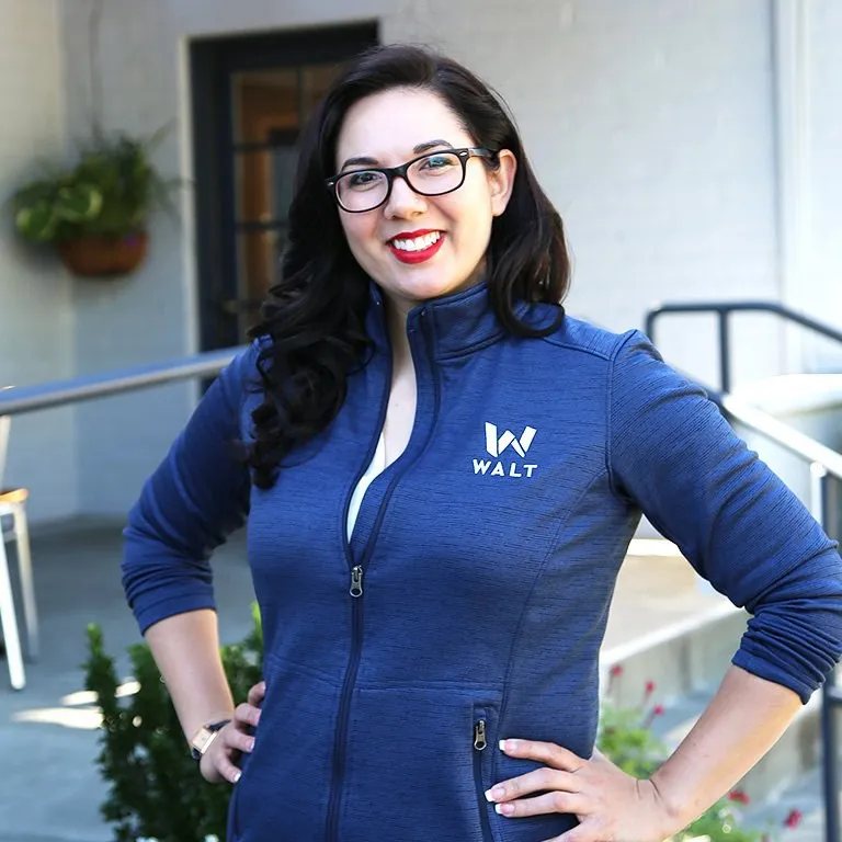 A smiling WALT team member in a navy WALT jacket