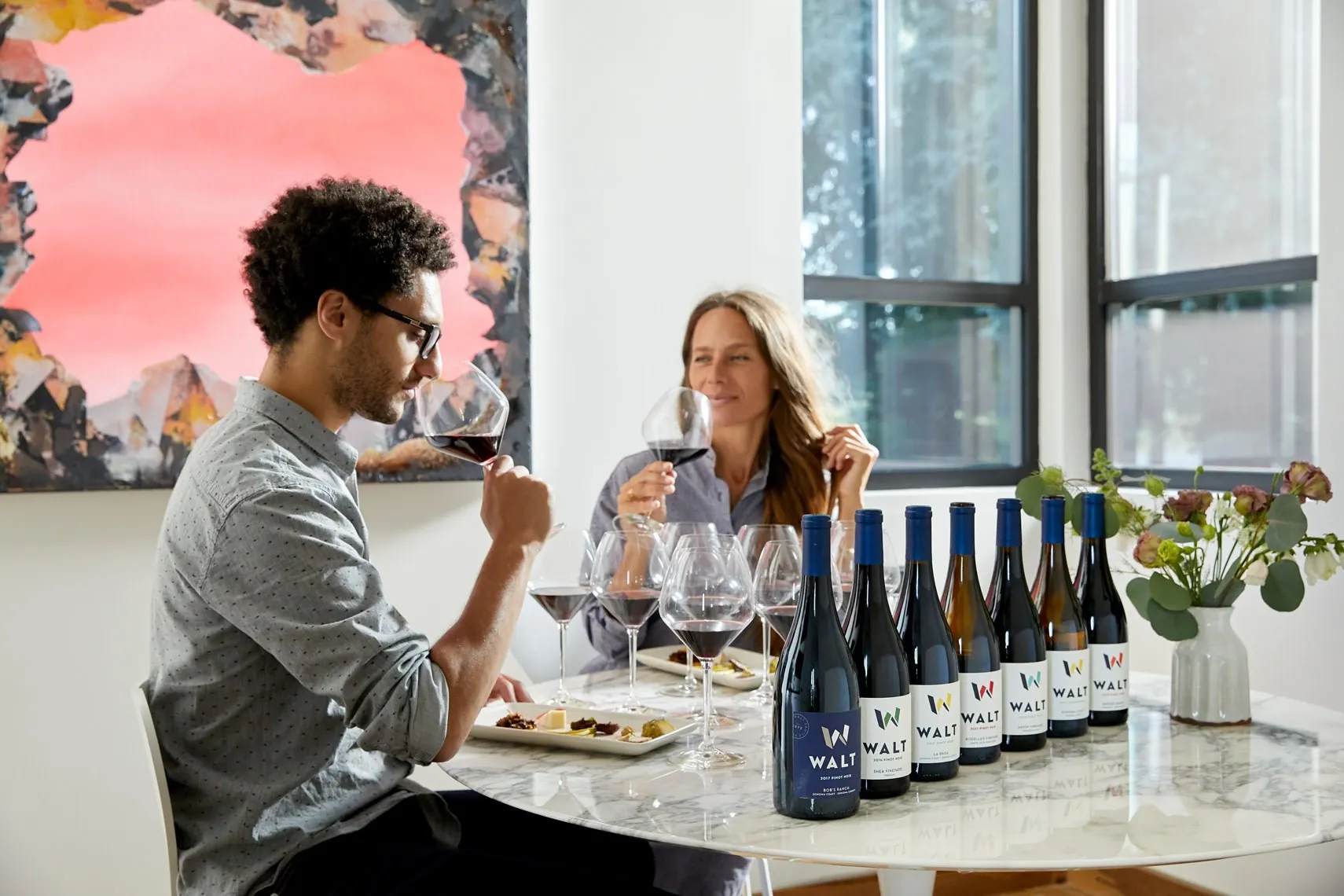 Two guests tasting a line of WALT wines at a marble table
